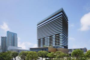 un edificio alto con árboles delante de él en The Westin Yokohama en Yokohama