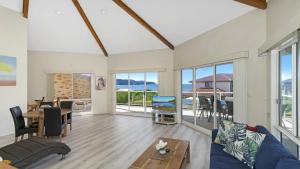 a living room with a blue couch and a table at Beach Break - Umina Beach Water Views in Umina