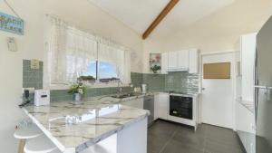 a large kitchen with a large marble counter top at Beach Break - Umina Beach Water Views in Umina