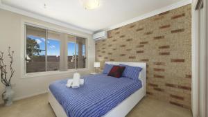 a bedroom with a bed and a brick wall at Beach Break - Umina Beach Water Views in Umina