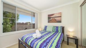 a bedroom with a bed and a large window at Beach Break - Umina Beach Water Views in Umina +10 photos