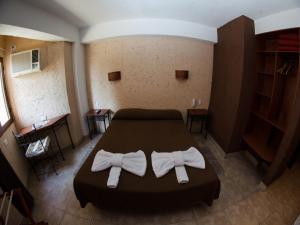 a bedroom with a bed with two white towels at Hotel Samka in Salta