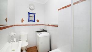 a white bathroom with a toilet and a shower at Beachcomber - Waterfront Umina Beach Wifi in Umina