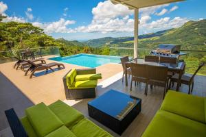 un patio con mesa, sillas y piscina en Casa Moderna con piscina en las Montañas de Altos del María en Sorá