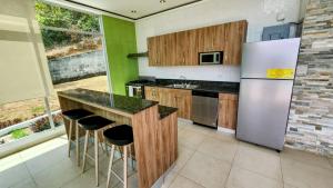 uma cozinha com armários de madeira e um frigorífico de aço inoxidável em Casa Moderna con piscina en las Montañas de Altos del María em Sorá