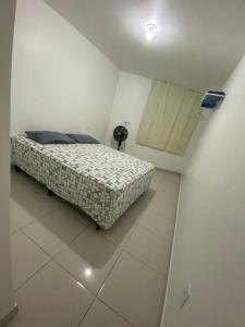 um quarto com uma cama num quarto branco em Apt05-06-07 no centro,a 800mts do pátio do forró em Caruaru