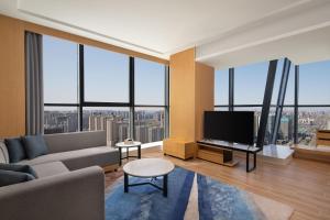 a living room with a couch and a tv at Fairfield by Marriott Shijiazhuang High-Tech Zone in Shijiazhuang