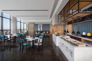 a restaurant with tables and chairs and a buffet at Fairfield by Marriott Shijiazhuang High-Tech Zone in Shijiazhuang