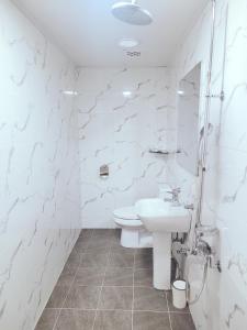 a white bathroom with a sink and a toilet at Seogwiporto in Seogwipo