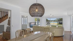 une salle à manger avec une table et un canapé dans l'établissement Family Beachhouse - Waterfront Ettalong Beach, à Ettalong Beach