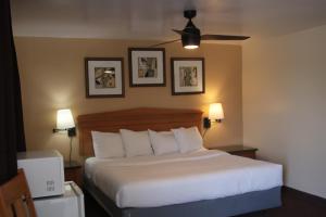 a bed in a hotel room with two pictures on the wall at Townhouse Motel in Lusk