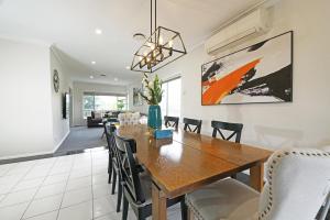 a dining room and living room with a wooden table and chairs at Doncaster Renovated 5BD/4BR Brick Home Parking WiFi in Doncaster