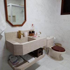 uma casa de banho com um lavatório e um WC em Chalés Alto do Capivari em Campos de Jordão