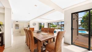 a dining room with a wooden table and chairs at Tranquil Lagoon - Waterfront Luxury in Daleys Point