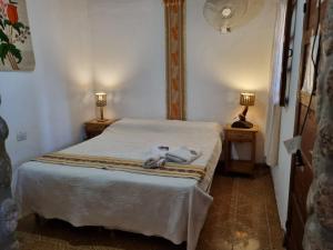 a bedroom with a bed with two lamps on two tables at Cardones de Molinos in Molinos