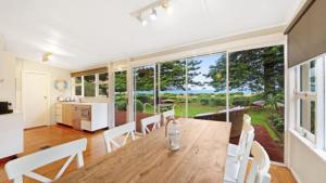 a kitchen and dining room with a table and chairs at Beach Shack - Waterfront Patonga in Patonga