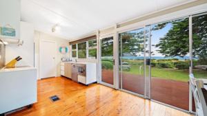 a kitchen with sliding glass doors leading to a patio at Beach Shack - Waterfront Patonga in Patonga