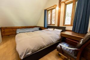 a bedroom with a bed and a desk and a chair at Log House Kizuki - Vacation STAY 62486v in Tsuru 