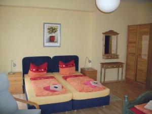 a bedroom with two beds with red pillows at Hotel Dänholm in Stralsund