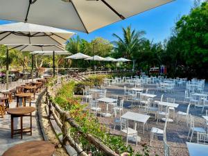 un groupe de tables et de chaises avec parasols dans l'établissement Seagate Bungalow Quy Nhon, à Quy Nhơn