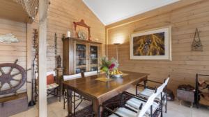 a dining room with wooden walls and a wooden table and chairs at Villa Pandanus - Patonga Beach in Patonga Beach