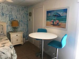 een kamer met een tafel en stoelen en een bed bij Cozy Studio only 10 minutes by car of Siesta Key in Sarasota