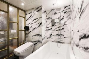 uma casa de banho com uma banheira branca e um WC. em Mariposa Hotel Songtan em Pyeongtaek