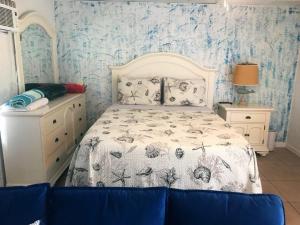 een slaapkamer met een bed en blauw en wit behang bij Cozy Studio only 10 minutes by car of Siesta Key in Sarasota