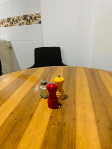 a wooden table with three different colored vases on it at Apartaestudio cerca al Aeropuerto in Bogotá