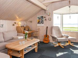 a living room with a couch and a table and a guitar at Holiday home Aabenraa LXX in Aabenraa