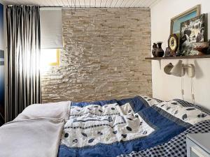 Holiday home GUSUM II في Gusum: سرير في غرفة نوم مع جدار من الطوب