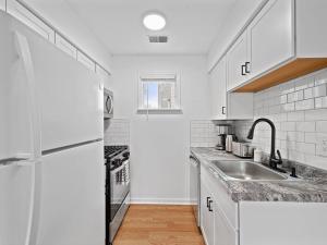 uma cozinha branca com um lavatório e um frigorífico em Bright, Quiet and Modern 1Bdr Apartment in Millvale, Lawrenceville em Pittsburgh