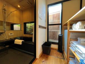 a bathroom with a tub and a sink in a room at Kamozen Kyoto Machiya Stay in Kyoto