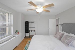 een witte slaapkamer met een plafondventilator en een bed bij 21st floor condo in the center of Atlanta in Atlanta