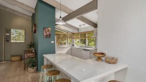 cocina con encimera blanca grande y algunas ventanas en Melaleuca Lodge - Pearl Beach, en Pearl Beach
