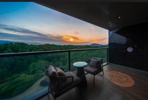 a room with a balcony with a view of a sunset at Banyan Tree Anji in Anji