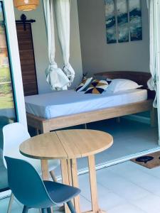 a bedroom with a bed and a table and a bed at HAMACA 107 KAWANN CENTER in Grand-Bourg