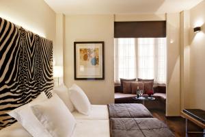 バルセロナにあるHotel Gran Derby Suites, a Small Luxury Hotel of the Worldのリビングルーム(白いソファ、シマウマの毛布付)
