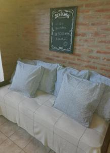 ein weißes Sofa mit blauen Kissen in einem Zimmer in der Unterkunft Departamento Centrico in Villa General Belgrano