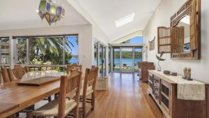 a dining room with a table and views of the ocean at Booker Bay Beach House Family Fun in Booker Bay