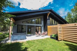 a house with a grill and a backyard at Le Boréal in Saint-Donat-de-Montcalm