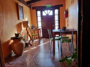 Habitación con mesa, sillas y puerta en Cardones de Molinos en Molinos