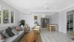 a living room with a couch and a table at Sam's Shack Waterfront Woy Woy Bay in Woy Woy