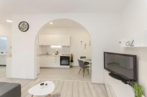 a white living room with a large flat screen tv at Apartment Maja with Jacuzzi in Rupe
