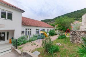 a yard with a playground in front of a house at Apartment Maja with Jacuzzi in Rupe