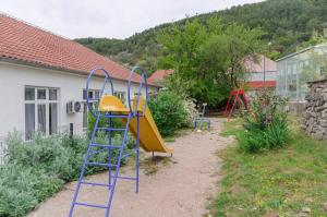 a playground with a slide in a yard at Apartment Maja with Jacuzzi in Rupe