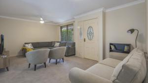 a living room with a couch and chairs at Banksia Villa Umina Beach in Umina