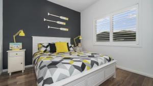 une chambre avec un lit noir et blanc et une fenêtre dans l'établissement Beach St Cottage - Ettalong, à Ettalong Beach