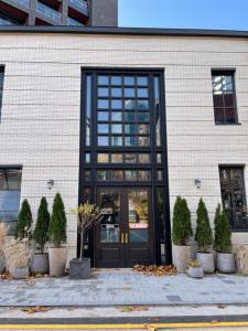a building with a black door and some plants at Junibino Hotel Hongdae in Seoul
