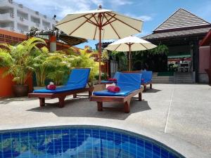 a group of chairs and umbrellas next to a pool at Kata Silver Sand in Kata Beach